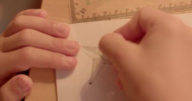 Bu odaklanmış anda, eller kağıt katlamakla ve ustalıkla kağıt tasarlamakla meşgul yaratıcı bir proje için kağıt coğrafyası dersinde önemli bir nokta sembolü oluşturuyorlar.