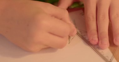 İş yerinde hem yaratıcılık hem de sanatsal ifade sergileyen, çizim yapan ellerin büyüleyici bir yakınlaşması, elleriyle kağıt üzerine bir sembol çiziyor.