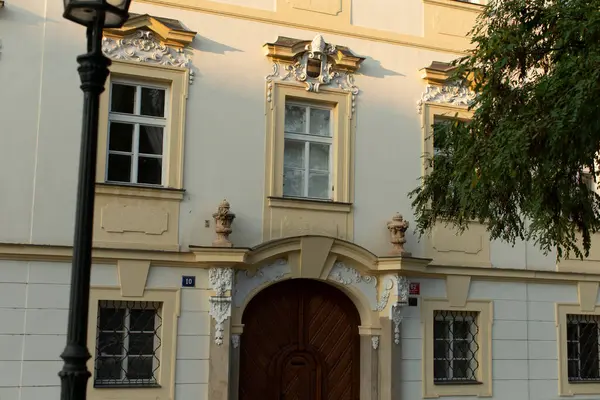 Bu resim, karmaşık dekoratif ayrıntıları ve güzel hazırlanmış ahşap kapıyla karakterize edilmiş son derece tarihi bir binanın ön görüntüsünü sergiliyor.