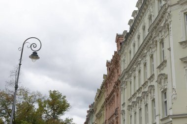 Sokak lambası şu anda cadde boyunca uzanan çeşitli binaların önünde duruyor.