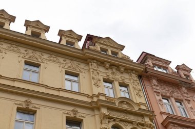 Arka planda, engin beyaz gökyüzünün altında mükemmel hizalanmış bir sıra bina var. Resimli bir şehir manzarası yaratıyor.