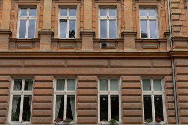 Geniş, çok katlı bir bina. Ön cephesini süsleyen bir sürü penceresi var. Doğal ışığın iç mekanları su basmasına izin veriyor.