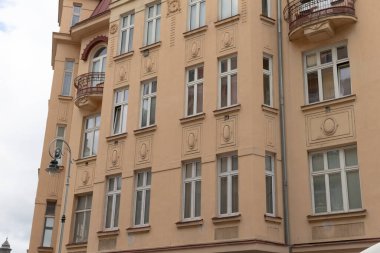 Tarihi bir binanın ayrıntılı cephesinde dekoratif pencereleri ve zarif balkonları sergileniyor.