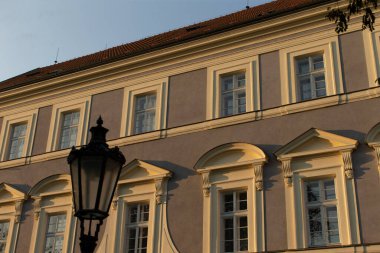 A historic building facade with beautiful windows and a charming lamp creates a picturesque scene clipart