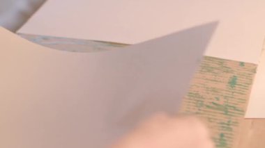 Kağıt parçalarını el ele yapıştırarak sınıfın yakın görüntüsünde desenli ahşap bir yüzeyi ve çeşitli sanatsal tasarımlar için ideal pürüzsüz kağıdı vurguluyor.