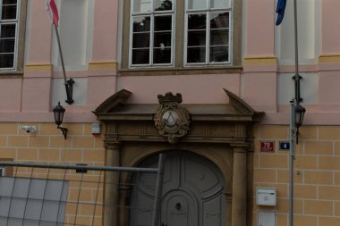 Binanın ön cephesi bir çitle çevrilidir. Bu çit, mülkiyet ve çevre arasında bir güvenlik unsuru oluşturur.