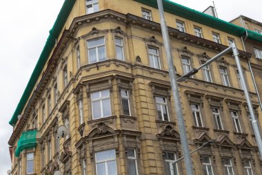 Belirgin yeşil bir çatısı olan büyük bir bina var ve tam önünde bölgeyi aydınlatan bir sokak lambası duruyor.