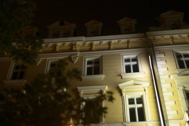 Gece boyunca sayısız pencereyle süslenmiş büyük bir bina güzelce aydınlatılır ve karanlık çöktükten sonra göz kamaştırıcı bir görüntü yaratır.