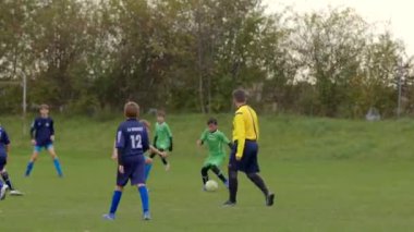 Bir gençlik futbol maçında CZ, Kralupy, 12.10.24 sahasında canlı yeşil ve mavi takımlı yetenekli oyuncular yer almaktadır.