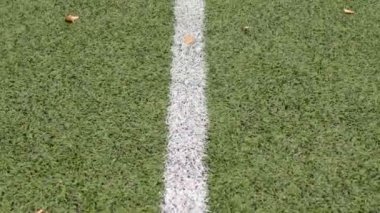 Yeşil spor sahasında beyaz çizgi, eşleşmeye hazır beyaz çizgi bir spor sahasının yapay çim yüzeyinin kesin sınırlarını belirler.