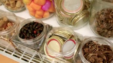 Çeşitli aromatik otlar, baharatlar ve kurutulmuş ürünler bir davet dükkanında güzelce sergileniyor.