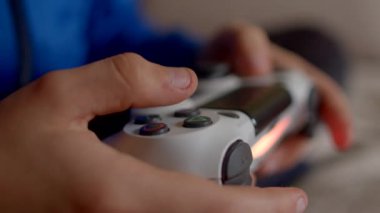 Bir oyuncu, oyun ve eğlenceye dalmış bulanık bir arka plana karşı bir denetleyiciyi sıkıca kavrar.