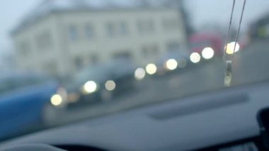 Yoğun bir trafik sahnesini kasıtlı olarak bulanık bir arka planla gösteren bir arabanın içi.