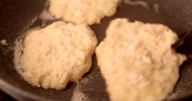 Lezzetli bisküviler tavada kızarıyor, yemek pişirme sürecini ve tereyağı kullanımını canlı canlı gösteriyor.