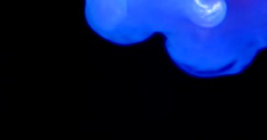 Bu büyüleyici video koyu mavi dumanı arka planda sergiliyor. Şişeden çıkarken büyüleyici ışık gizemli bir atmosfer yaratır.