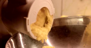 Lezzetli bir patates karışımı ezici bir eklenti tarafından servis kasesine çıkarılıyor.