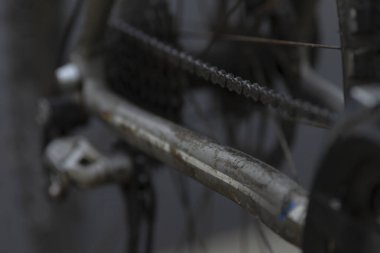 Bu, bir yol yüzeyindeki bisiklet zincirinin karmaşık detaylarını gösteren, temel mekanik özelliklerini gösteren yakın plan bir resim.