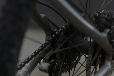 Bu, tekerleğin üzerinde karmaşık bir şekilde yerleştirilmiş, ayrıntılı bileşenleri ve tasarımı gösteren bir bisiklet zincirinin yakın görüntüsü.