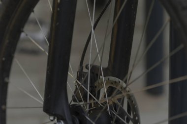 Bu resim, en iyi frenleme performansı için disk fren sistemini belirgin bir şekilde gösteren bir bisiklet tekerleğinin ayrıntılı yakın çekimini içerir.