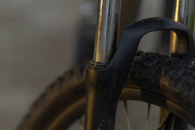 Bu bir bisiklet çatalının yakın çekim görüntüsü, lastiğinin yanında, bisiklet bileşenlerinin karmaşık detaylarını vurguluyor.