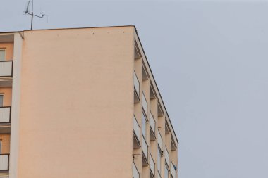 Çok yüksek bir bina, birden fazla balkonu ve yapısının en tepesine yerleştirilmiş bir anten var.