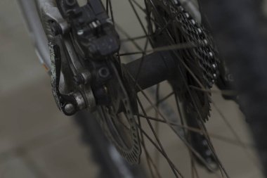 Bu, fren sistemi, zinciri ve işlevsellik için gerekli olan çeşitli bileşenleri gösteren bisiklet tekerleğinin detaylı bir yakın çekimi.