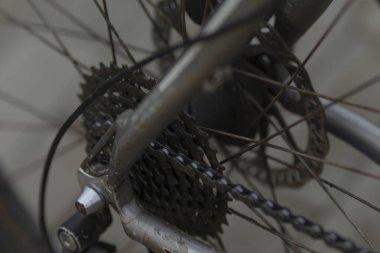 Görüntü, bir bisikletin arka kısmının ayrıntılı bir yakın çekim görüntüsünü gösterir, özellikle zincir mekanizması ve bileşenlerini göstermektedir.