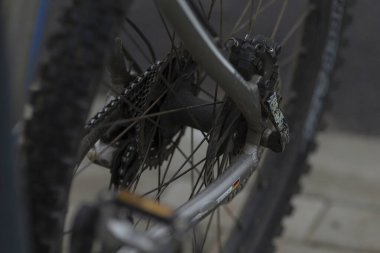 Bir bisikletin arka tekerleğinin detaylı yakın plan fotoğrafı. Karmaşık parçaları ve bileşenleri açıkça gösteriyor.