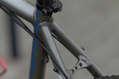 Bu, canlı bir mavi kabloya sahip bir bisikletin yakın plan görüntüsü, motorun karmaşık dizaynını ve gerekli bileşenlerini gösteriyor.