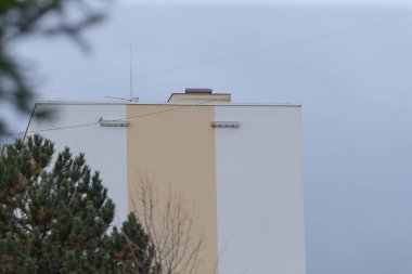 Önünde yemyeşil bir ağacın bulunduğu uzun, etkileyici bir bina var. Çok güzel bir manzara yaratıyor.