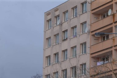 Çok sayıda pencere ve balkon barındıran geniş ve büyük bir apartman, şehirde canlı bir şehir atmosferi yaratıyor.