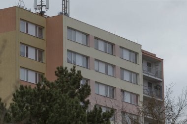 En tepesine bir anten yerleştirilmiş, ufuk çizgisine karşı dik duran büyük ve etkileyici bir apartman.
