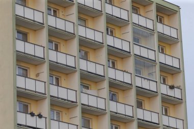 Etkileyici yapı, sayısız balkonları ve doğal ışık getiren pencereleri olan büyük bir apartman.