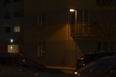 Bir sokak lambası gece boyunca bir binanın önündeki alanı aydınlatacak ve karanlıkta sıcak bir parıltı yaratacak.