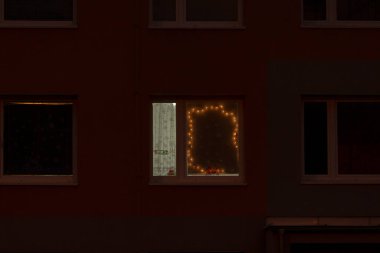 Renkli Noel ışıklarıyla süslenmiş, geceleri aydınlatılmış, neşeli bir atmosfer yaratan güzel bir bina.