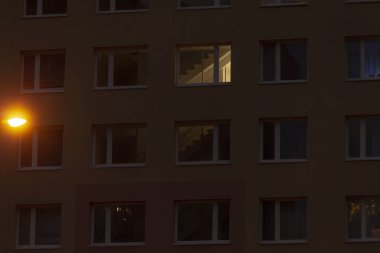 Çok sayıda penceresi olan yüksek bir bina gece boyunca güzelce aydınlatılır ve herkesin görebileceği büyüleyici bir manzara yaratır.