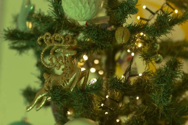 Çok güzel süslenmiş bir Noel ağacının detaylı bir görüntüsü göz kamaştırıcı süslemeler ve neşeyle parlayan parlak ışıklarla dolu.