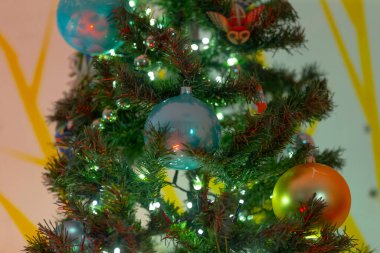 Güzel süslenmiş bir Noel ağacı canlı mavi ve turuncu süslemelerle süslenir ve bayram sezonuna şenlikli bir dokunuş eklenir.