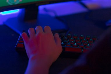 Bir kişi şu anda kendisi için içeriği gösteren bir bilgisayar monitörünün önünde konumlanmış bir klavyede yazıyor.