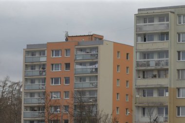 Oldukça bulutlu bir günde bulutlu bir gökyüzünün arka planına karşı balkonları olan bir dizi çok katlı apartman.