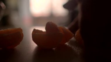 Citrus segmentleri bir masanın üzerine ustalıkla yerleştirilmiş, yumuşak ışıklandırılmış arka plan sahneye sıcaklık katıyor.
