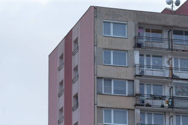 Bu, birden fazla balkon ve çok sayıda penceresi olan bir binanın dış görünüşü.