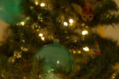 A detailed close up of a beautifully decorated Christmas tree featuring an array of vibrant blue ornaments enhancing its festive appearance clipart