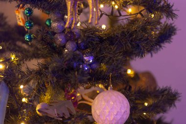 Here is a closeup view of a beautifully decorated Christmas tree adorned with stunning purple lights and a variety of festive decorations clipart