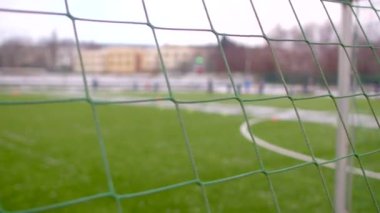 Futbol kalesinin sezonki gol kalesi boyunca hareketli olması güzel bulanık bir arka plana sahip yemyeşil bir sahada duruyor ve hareketlilik yaratıyor.