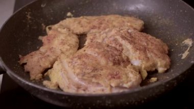 Lezzetli kızarmış tavuk parçaları tavada kızarıyor ve nefis bir altın kaplama yapıyor.