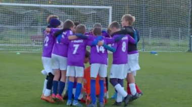 Bir grup hevesli genç futbolcu, sahadaki zorlu takım zaferini sevinçle kutluyor. CZ, Kladno, 18.10.24