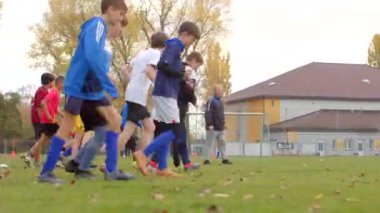 Canlı bir yeşil alan CZ, Unhost, 10.24 'te aktif olarak futbol antrenmanına katılan bir grup çocuk.