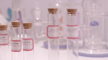 Çeşitli alanlarda etiketli test tüpleri ve laboratuvar camları, bilimsel araştırmalar ve deneysel uygulamaların toplanması.
