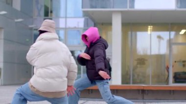 Şehir yaşamının uğultusunun ortasında, canlı bir şehir ortamında iki kişi neşeyle dans ediyor.